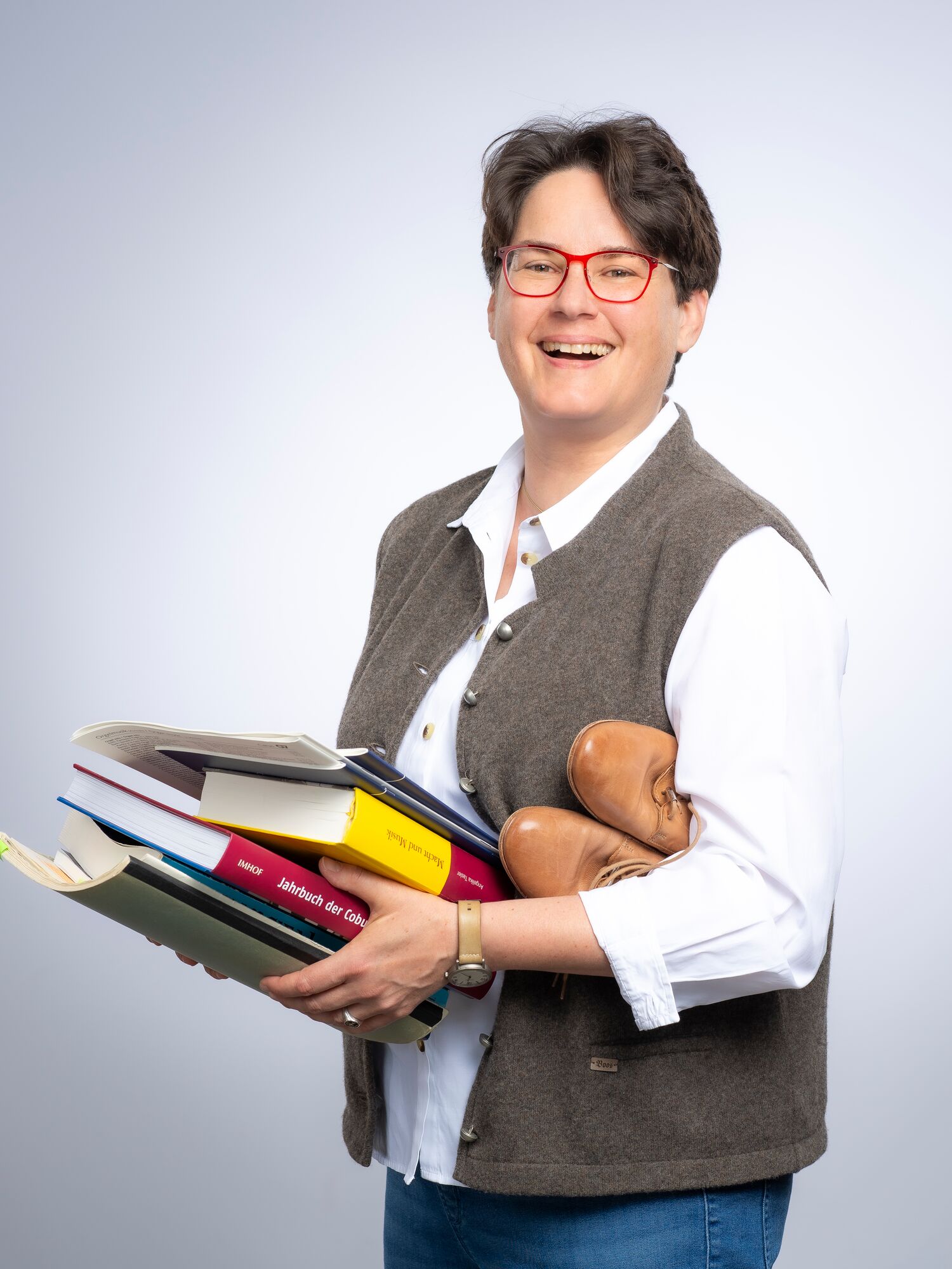 Dr. Angelika Tasler. Musikwissenschaftlerin & Musikerin - Am Schreibtisch sitzend mit Büchern.