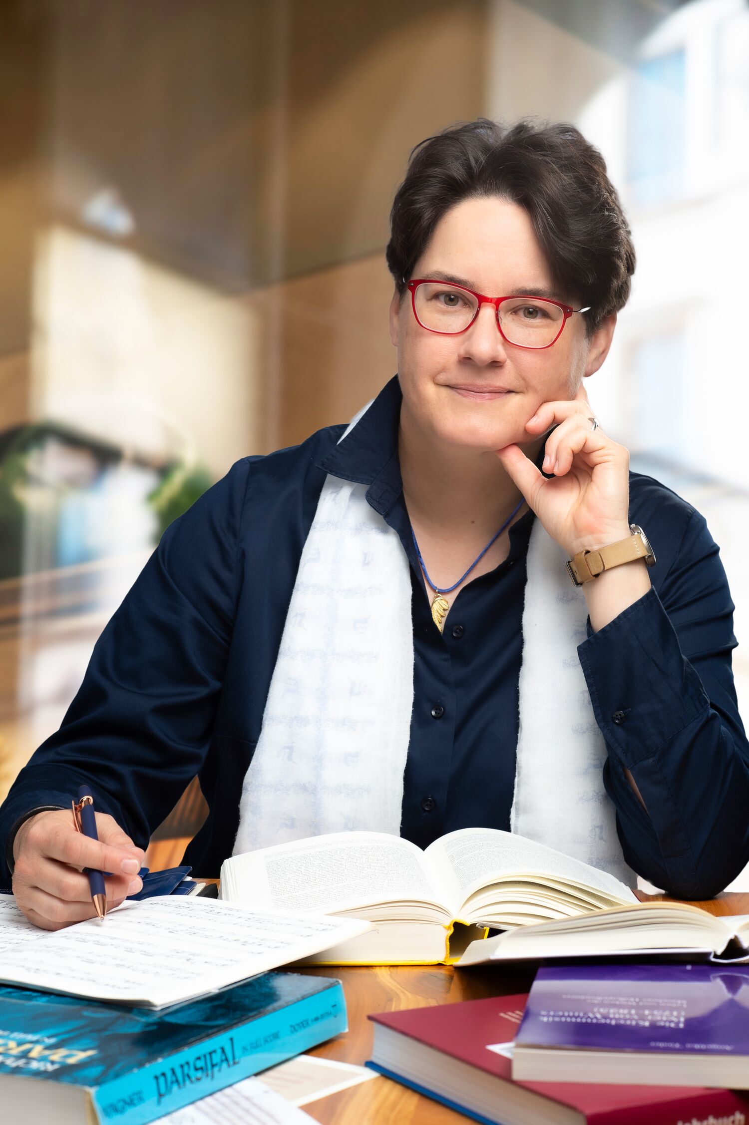 Dr. Angelika Tasler. Musikwissenschaftlerin & Musikerin - Am Schreibtisch sitzend mit Büchern.
